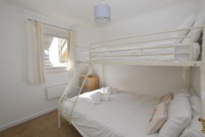 a bedroom with two bunk beds and a window at Beach View Apartments in Porthtowan