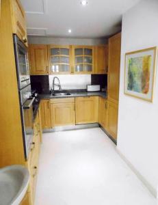 a kitchen with wooden cabinets and a sink at Aprtment at Abu Tig Marina - MP6 in Hurghada