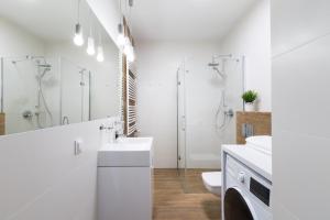 biała łazienka z umywalką i toaletą w obiekcie Luksusowy apartament przy Targach w Poznaniu