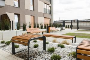 grupa ławek siedzących przed budynkiem w obiekcie Luksusowy apartament przy Targach w Poznaniu