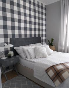 a bedroom with a bed and a checkered wall at Mieszkanie przy Plazy in Ustronie Morskie