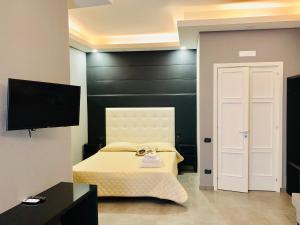 a bedroom with a bed and a black wall at Royal Art H Duomo - Napoli Centro, by ClaPa Group in Naples