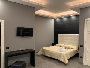 um quarto com uma cama e uma televisão de ecrã plano em Royal Art H Duomo - Napoli Centro, by ClaPa Group em Nápoles