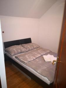 a bed in a small room with a door at Sobe i apartmani Lipa 12 in Repušnica