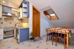 a kitchen with a table and chairs in a room at House Topic in Baška Voda