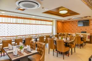 a restaurant with tables and chairs and a screen at Hotel Suncity Plaza, Sitapura, Jaipur in Jaipur