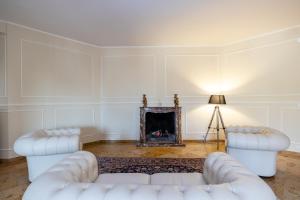 a living room with two white couches and a fireplace at Scaligero Rooms in Verona