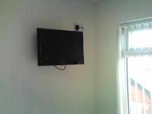 TV de pantalla plana colgada en la pared en Arlingtons, en Blackpool