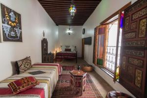 ein Wohnzimmer mit 2 Betten und einem Fenster in der Unterkunft Riad Sanaa Rose in Fès