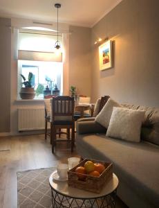 a living room with a couch with a bowl of fruit on a table at Mieszkanie przy Plazy in Ustronie Morskie