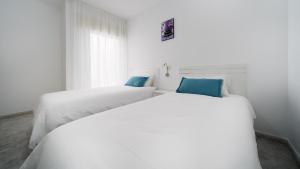 two beds in a room with white and blue at Armonía Beach 17 in Arinaga