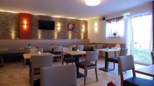 a restaurant with tables and chairs and a tv on the wall at ST Michael Atrona GmbH in Euskirchen