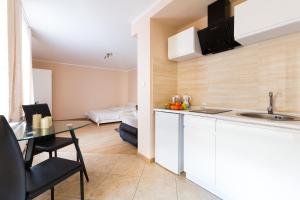 uma cozinha com um lavatório e uma mesa num quarto em ApartHouse Apartamenty Centrum em Sosnowiec