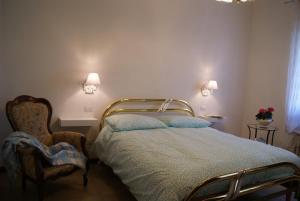 a bedroom with a bed and a chair and two lights at home paolina in Greve in Chianti