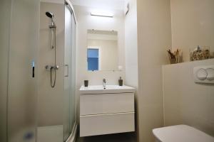 a bathroom with a sink and a shower at Apartament Jarzębina in Kołobrzeg