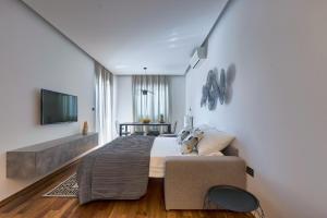 - une chambre avec un grand lit et une télévision dans l'établissement Adriatic Apartments, à Fažana