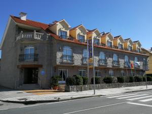 un gran edificio al lado de una calle en Hotel Playa Compostela en Vilagarcía de Arousa