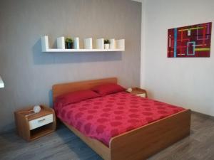 een slaapkamer met een bed met een rood dekbed bij Villa Giuliana in Cannobio