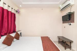 烏賈因的住宿－Hotel Rameshwaram，一间卧室配有床和红色窗帘