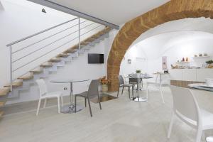 um quarto com uma escada e mesas e cadeiras em Colle Greco em Agrigento