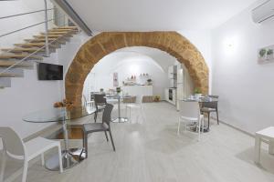 uma sala de jantar com um arco e mesas e cadeiras em Colle Greco em Agrigento
