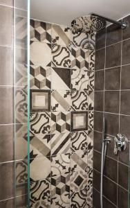 eine Dusche mit schwarzen und weißen Fliesen in der Unterkunft La Rosa del Corso in Fasano