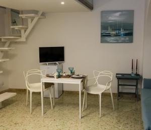 uma sala de estar com uma mesa branca e cadeiras em La Rosa del Corso em Fasano