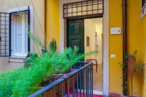 een geel huis met een groene deur en wat planten bij Zefiro Home in Rome