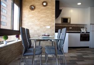 eine Küche und ein Esszimmer mit einem Tisch und Stühlen in der Unterkunft Sur Suites Palmeras 3 in Fuengirola
