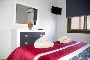 ein Bett mit zwei weißen Handtüchern darüber in der Unterkunft Sur Suites Palmeras 3 in Fuengirola