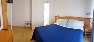 a blue and white bed in a room with a window at Hotel Mare Blu -- boutique in Pineto