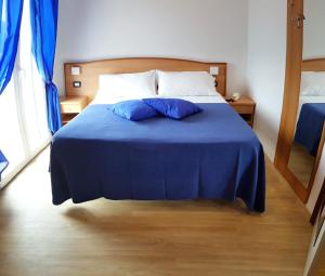 a bedroom with a blue bed with two pillows on it at Hotel Mare Blu -- boutique in Pineto