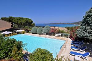 an overhead view of a swimming pool with chairs and the ocean at Domaine de Saint Pierre in Cargèse