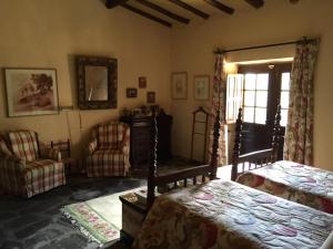 a bedroom with a bed and two chairs and a window at Quinta do Vale Coelheiro in Toulões