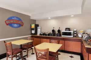 a breakfast room with two tables and a microwave at Baymont by Wyndham Lithia Springs Atlanta in Lithia Springs