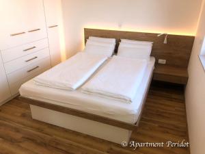 VILA Mojca - APARTMENT PERIDOT - Center في كراجسكا غورا: غرفة نوم بسريرين مع شراشف ووسائد بيضاء