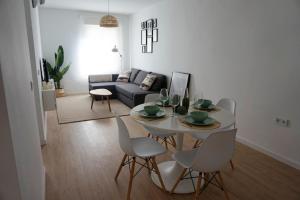 隆达Ronda Chic Apartments - C/ Lauria - Centro ciudad的客厅配有白色的桌子和椅子