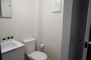 隆达Ronda Chic Apartments - C/ Lauria - Centro ciudad的白色的浴室设有卫生间和水槽。 更多8张照片