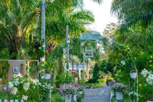 a garden with a gate and flowers and palm trees at View Dao Jantra in Chachoengsao