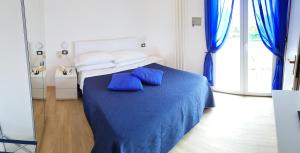a bedroom with a blue bed with blue pillows at Hotel Mare Blu -- boutique in Pineto