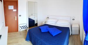 a bedroom with a bed with blue sheets and pillows at Hotel Mare Blu -- boutique in Pineto