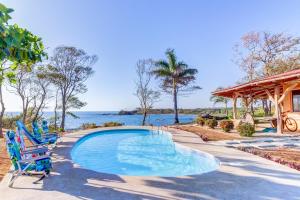 una piscina con sillas y el océano en el fondo en Casa Don Marcos, en Playa Azul