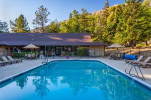 a swimming pool with chairs and a house at Big Sur Lodge in Big Sur