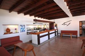 a bar in a restaurant with red chairs and tables at Domaine de Saint Pierre in Cargèse