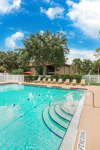 a swimming pool with people in the water at Alhambra Villas in Kissimmee