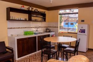 a kitchen with a table and some chairs and a table at Departamentos Santa Ana Barrio Tradicional in Cusco