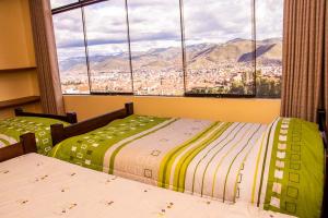 two beds in a room with a view of a city at Departamentos Santa Ana Barrio Tradicional in Cusco