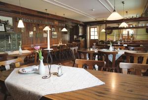 un restaurante con una mesa con flores, mesas y sillas en Hotel Daimerwirt, en Moosinning