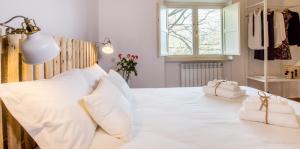 a bedroom with a white bed with two towels on it at Bonjour Bonheur in Avellino