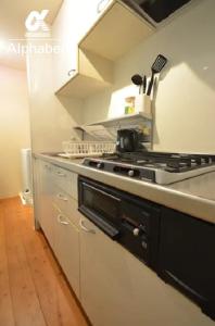 a kitchen with a stove and a counter top at Alphabed TakamatsuKawaramachi WEST 701 / Vacation STAY 21586 in Takamatsu
